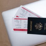 close up shot of a passport and tickets on top of a laptop